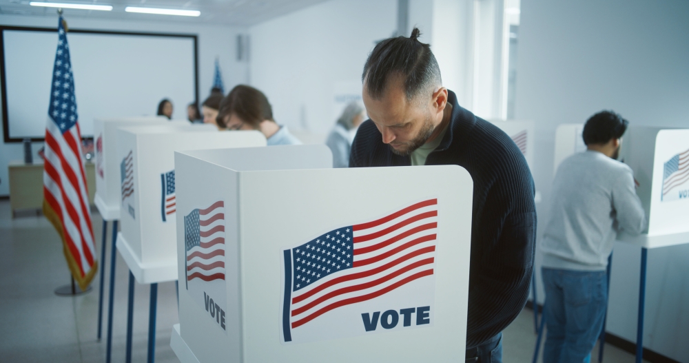 man filling out ballot in voting booth